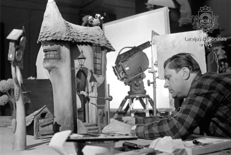 Režisors Arvīds Noriņš pie leļļu filmas "Bums un Piramidons" (1969) mednieka Buma mājas maketa. // Foto – Latvijas Nacionālais arhīvs